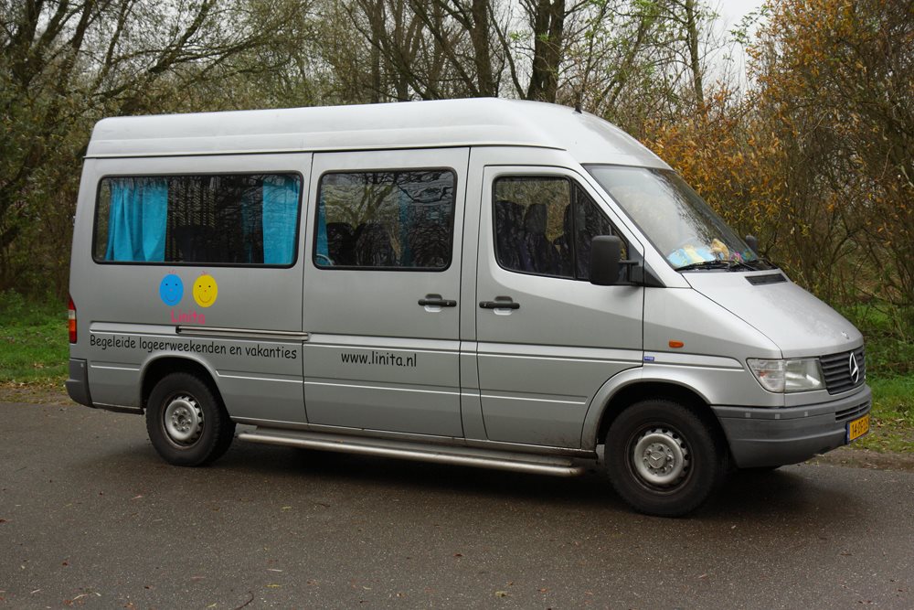 Zilvergrijze rolstoelbus.