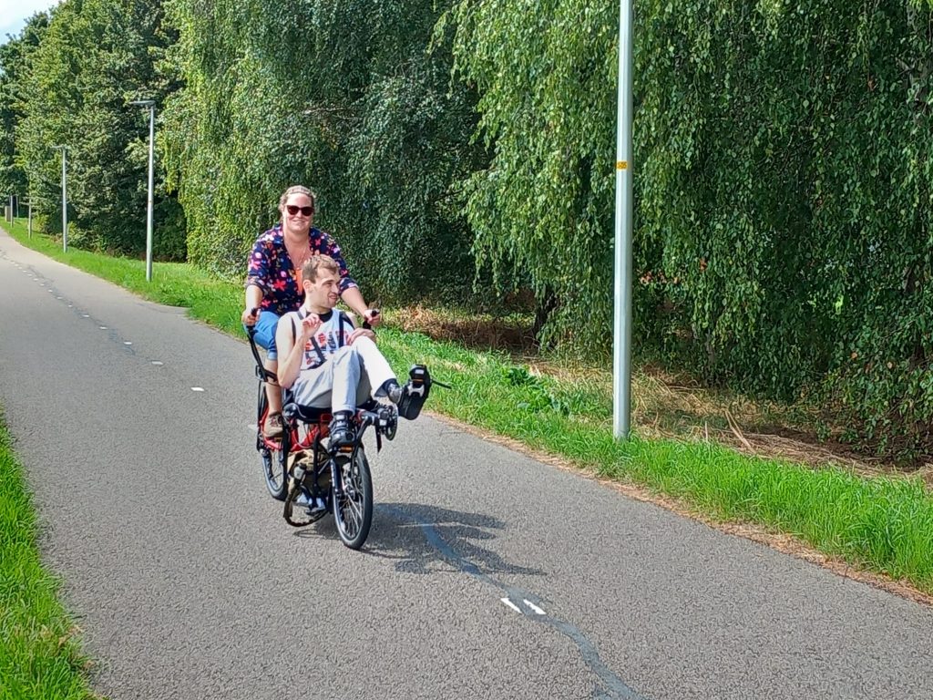 Linda fietst op één fiets met cliënt.